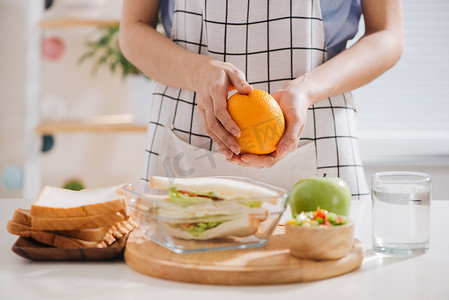 亚洲女性为健康饮食的孩子（孩子）准备食物（水果和蔬菜）。