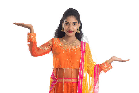 欢快的印度传统年轻女性手拿东西的肖像，在白色背景下手掌上展示复制空间