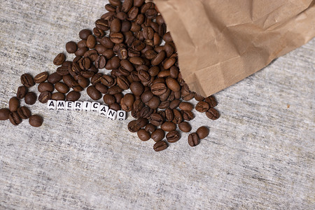 靠近用白色小方块写的 AMERICANO 字样的新鲜烘焙咖啡豆的特写。