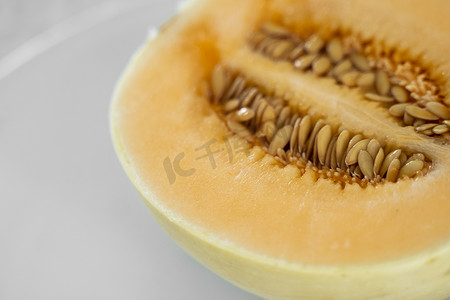 白盘上的新鲜甜橙瓜作为背景，有选择性地聚焦。