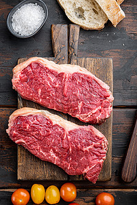 肉俯视摄影照片_生牛肉牛排汉堡配料配大理石肉，放在旧木桌上，俯视