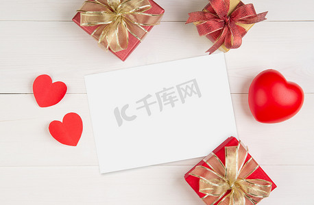 明信片模板摄影照片_空白明信片大小 a5 和字母和礼品盒和木桌上的心形，样机贺卡和模板，装饰浪漫，庆祝情人节和节日概念。
