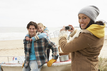 拍全家福摄影照片_母亲在冬季海滩上拍全家福