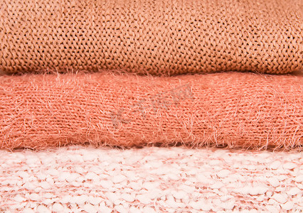 家庭衣橱架子上堆着温暖的秋冬针织毛衣。