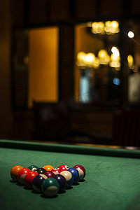 台球价格表摄影照片_在舒适的黑暗酒吧内部台球桌上的台球