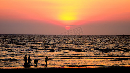 现出轮廓的人走在海上与夕阳的天空