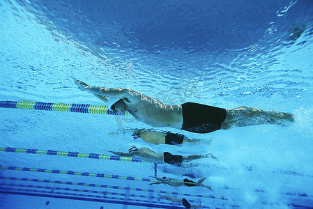 游泳运动员摄影照片_男性游泳运动员在泳池水下比赛中比赛