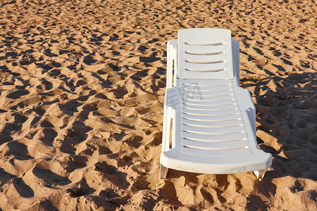 沙滩日光浴摄影照片_沙丘沙滩上的沙滩日光浴浴床和写作的地方
