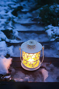 冬季公园旧木楼梯上燃烧蜡烛的装饰灯笼