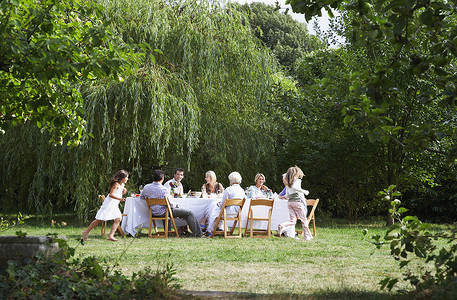 一家人在花园里的餐桌旁吃饭