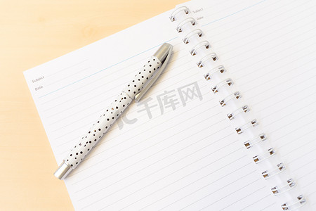 打开带有线条的白色笔记本和带有商务 C 的白色圆点笔