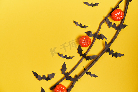 感恩节贺卡贺卡摄影照片_万圣节背景，橙色装饰塑料南瓜黑纸蝙蝠黄卡纸感恩节贺卡