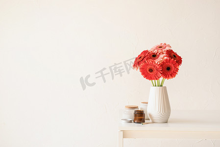 厨房桌上白色花瓶中明亮的非洲菊雏菊，简约风格