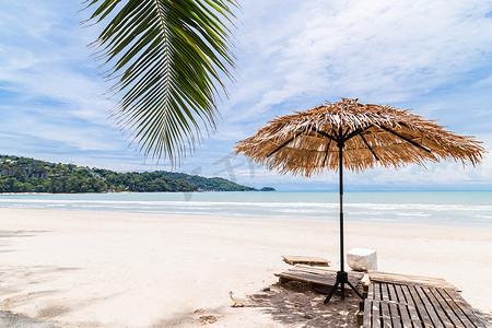 沙滩伞由棕榈叶制成，位于泰国大海前的完美白色沙滩上。