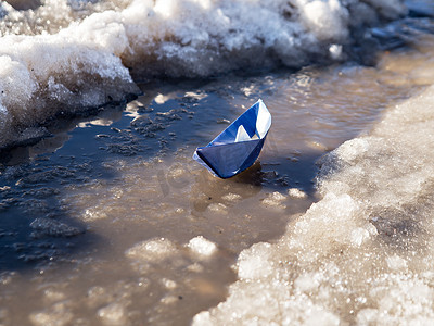 纸船在融雪中漂浮在水面上