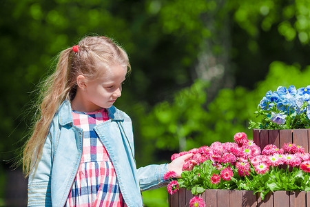 郁金香女孩摄影照片_盛开的郁金香花园里的小可爱女孩。
