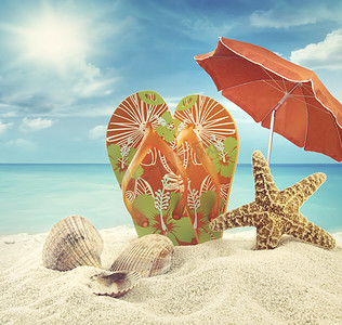 凉鞋和带沙滩伞的海星在海洋