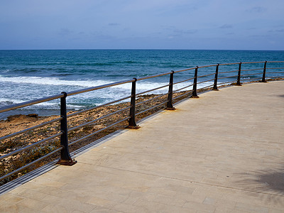 海滨长廊摄影照片_带金属栏杆的美丽海滩海滨长廊