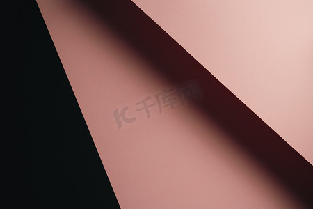 柔和的粉红色和黑色平底背景，具有清晰的层次和带复制空间的阴影