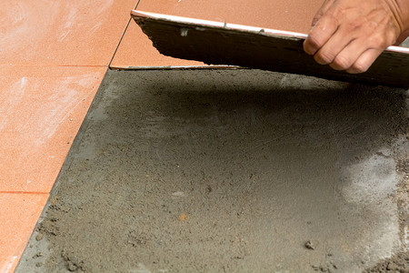 男建筑工人在家贴瓷砖，瓷砖地板粘合剂 r