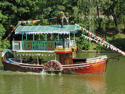 河边散步摄影照片_一艘两层楼的小船，供游客沿着河边散步。