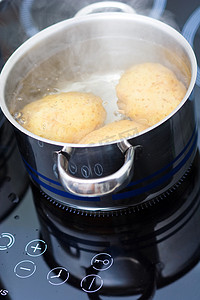 蓝色水煮摄影照片_土豆在水里煮