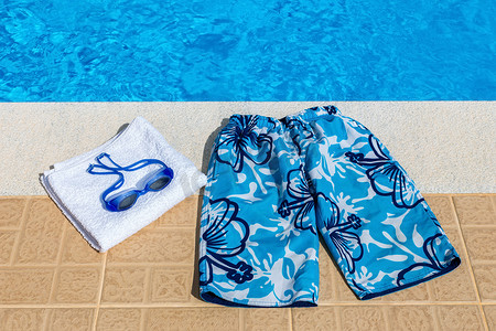 游泳池的泳裤护目镜和毛巾