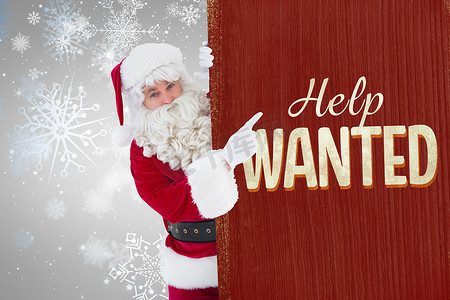 冬天海报摄影照片_微笑的圣诞老人指向海报的合成图像