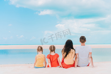 年轻的四口之家在海滩度假