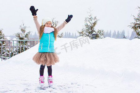 可爱的小女孩在冬季雪天在户外滑冰