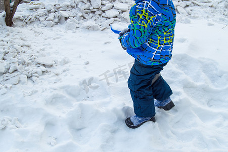 小铲子摄影照片_迷人的小男孩在冬日挖雪蓝色小铲子