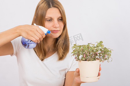 女孩用洒水器给花浇水