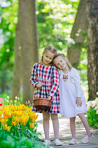 走在郁金香郁郁葱葱的花园里的小可爱女孩