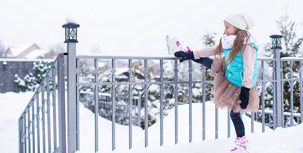 滑冰孩子摄影照片_可爱的小女孩在冬雪天滑冰