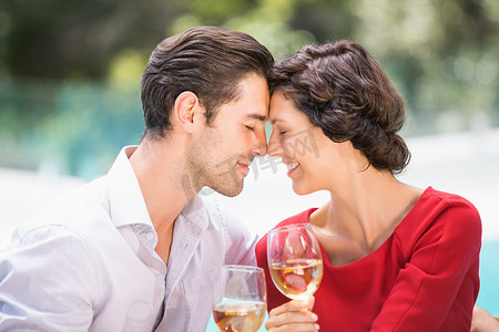 浪漫的情侣拿着白葡萄酒闭着眼睛