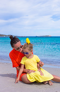 热带海滩度假期间的小女孩和快乐妈妈