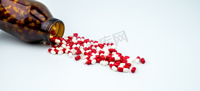 五颜六色的抗生素胶囊药片与两个琥珀色玻璃瓶隔离在白色背景。