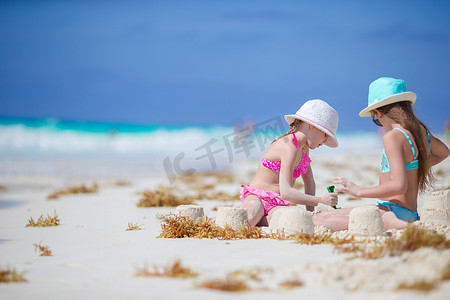 可爱的小孩在白色的沙滩上玩沙子