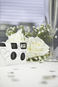 摄影机摄像机摄影照片_婚礼桌上的一次性白色婚礼相机。