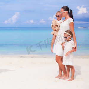 家庭度假摄影照片_母亲和可爱的女孩在海滩度假