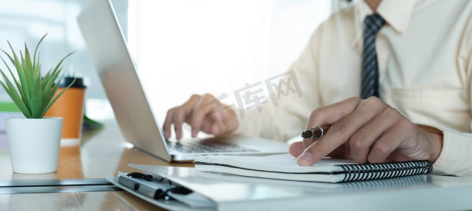 关闭商人使用笔记本电脑在办公室和商业工作背景、税务、会计、统计和分析研究概念的木桌上做数学金融