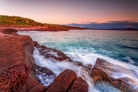 在伊甸园富有的红色岩石海岸的清早