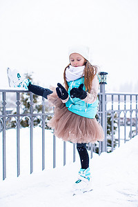 可爱的小女孩在冬雪天滑冰
