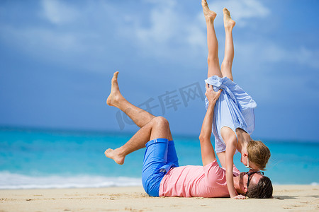 小女孩和快乐的爸爸在海滩度假时玩得很开心