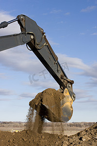 挖掘机臂和铲斗在道路施工中挖土