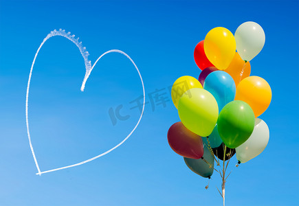 庆祝气球摄影照片_五颜六色的气球和飞机写在天空的心