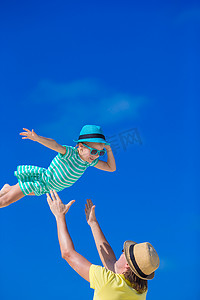 热带海滩度假期间的小女孩和年轻父亲