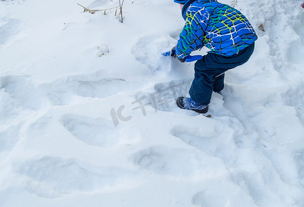 迷人的小男孩在冬日挖雪蓝色小铲子