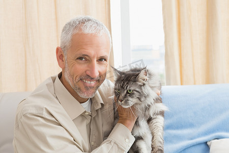 快乐的男人和他的宠物猫在沙发上