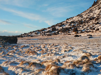 冬天，冰岛一座山脚下长满苔藓的冰冻熔岩田。